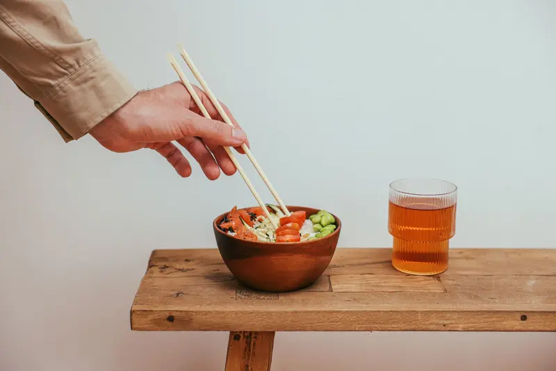 一隻手伸向擺滿配料的飯碗
