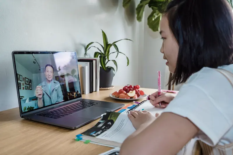 一名學員在餐桌前用筆電上視訊課