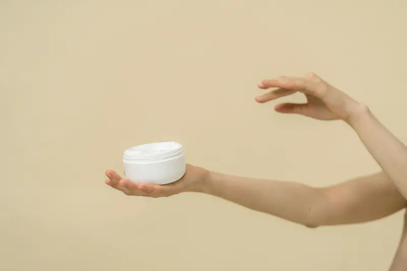 手掌托著打開的白色乳霜罐