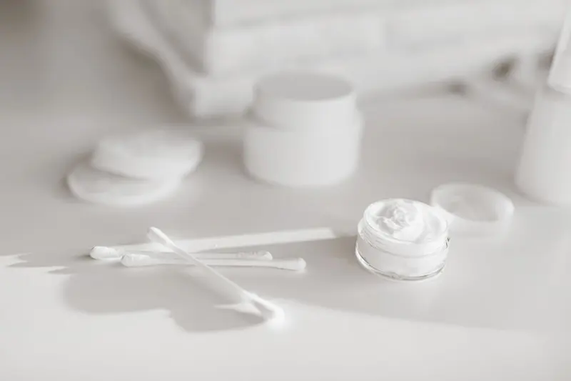白色瓶罐、棉花棒與挖出的乳霜質地