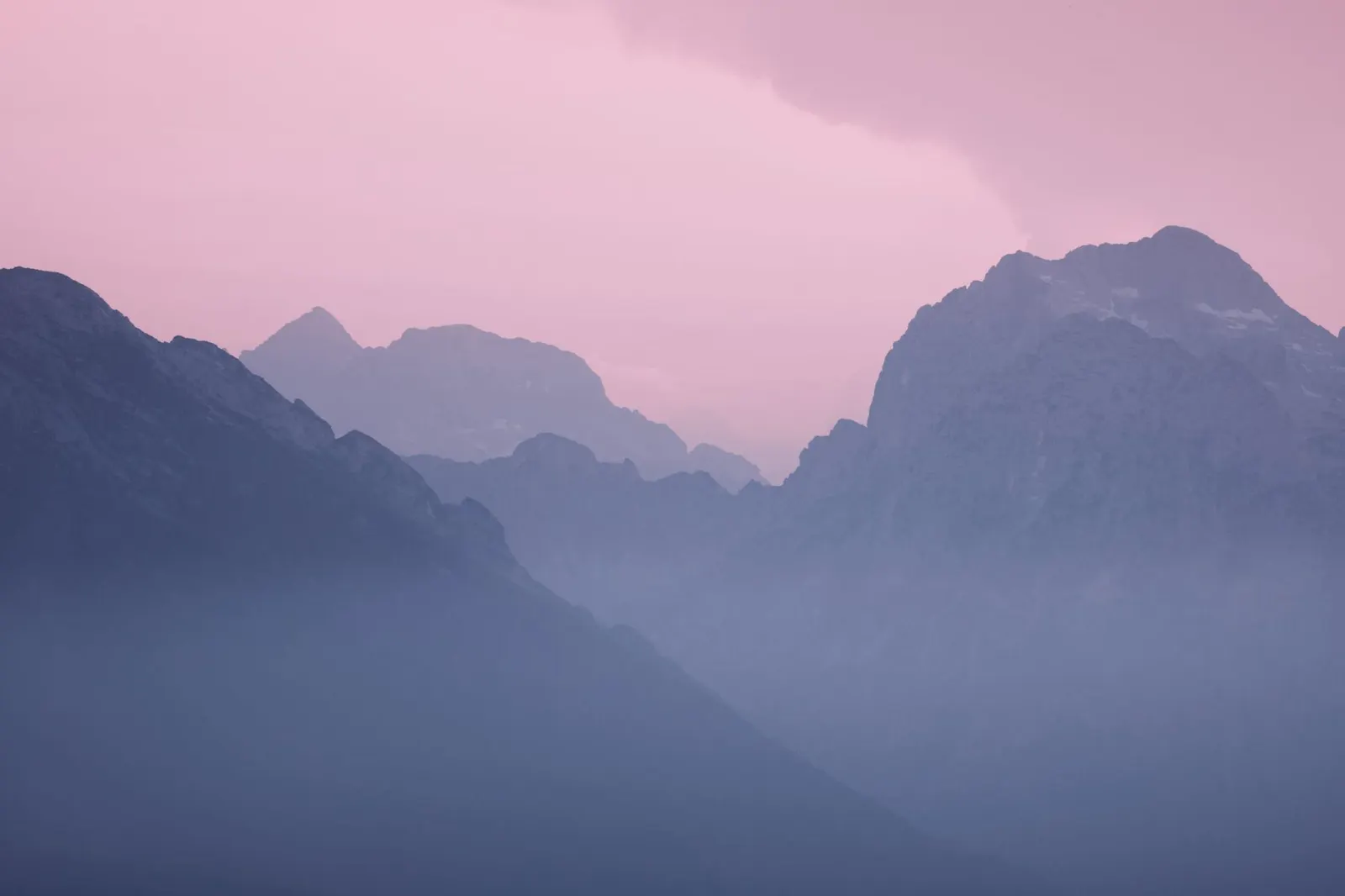 粉紅色天空下的雲霧山峰
